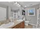 Bright bathroom featuring a double vanity, decorative mirror, and a shower/tub combo with a curtain at 250 Spring View Ln, Pittsboro, NC 27312