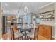A dining room with a round glass table, seating for four, and hardwood floors, open to kitchen at 250 Spring View Ln, Pittsboro, NC 27312