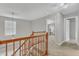 Bright hallway upstairs with wood railing, neutral walls, and access to other rooms at 250 Spring View Ln, Pittsboro, NC 27312