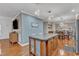 An open kitchen with wood flooring, a kitchen island, modern lighting, and stainless steel appliances at 250 Spring View Ln, Pittsboro, NC 27312