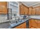 Kitchen area featuring stainless steel sink, tile backsplash, and wood cabinets at 250 Spring View Ln, Pittsboro, NC 27312