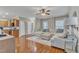 Cozy living room featuring an oversized couch, hardwood floors and access to kitchen and bathroom at 250 Spring View Ln, Pittsboro, NC 27312
