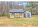 View of two storage sheds with double doors and windows in a large back yard at 250 Spring View Ln, Pittsboro, NC 27312