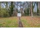 A fenced backyard with a small storage shed and mature trees at 304 22Nd St, Butner, NC 27509