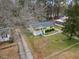 Aerial view of a charming yellow home with a well-manicured front lawn and inviting porch at 304 22Nd St, Butner, NC 27509