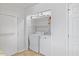 Clean laundry room with essential appliances, storage shelves, and access door at 304 22Nd St, Butner, NC 27509