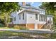 Side of home featuring a brick foundation, white siding, and access stairs at 309 College St, Oxford, NC 27565