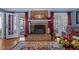 Living room brick fireplace with a decorative mantel, hardwood floors, and French doors at 3222 Windmere Dr, Sanford, NC 27330