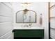 Stylish powder room with green vanity, gold accents, and a decorative mirror at 336 Timberline Dr, Pittsboro, NC 27312