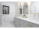 Elegant bathroom with double vanities, gold-framed mirrors, neutral grey cabinets and a black-trimmed window at 336 Timberline Dr, Pittsboro, NC 27312