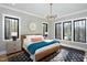 This bedroom features black-framed windows, natural light, modern light fixture, and a decorative wall hanging at 336 Timberline Dr, Pittsboro, NC 27312
