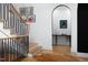 Foyer with modern staircase and beautiful hardwood floors leading to an arched doorway at 336 Timberline Dr, Pittsboro, NC 27312