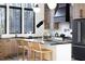 Modern kitchen featuring black countertops, natural wood cabinets, and stainless-steel appliances at 336 Timberline Dr, Pittsboro, NC 27312