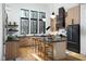 Open kitchen concept boasting natural wood cabinetry, black countertops, and modern lighting fixtures at 336 Timberline Dr, Pittsboro, NC 27312