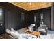 Covered outdoor patio with stylish seating, wooden ceiling, and dark exterior for relaxing or entertaining guests at 336 Timberline Dr, Pittsboro, NC 27312