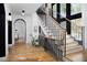 Elegant staircase with modern railing, hardwood floors, and large windows, creating a bright and open space at 336 Timberline Dr, Pittsboro, NC 27312