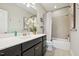 Well-lit bathroom with a shower/tub combo, dark vanity, and a white countertop at 3929 Glenlake Garden Dr, Raleigh, NC 27612