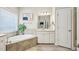 Serene bathroom features a soaking tub, granite counters, and ample natural light, creating a spa-like retreat at 3929 Glenlake Garden Dr, Raleigh, NC 27612