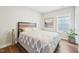 Comfortable bedroom with hardwood floors, a patterned comforter, and plenty of natural light from the window at 3929 Glenlake Garden Dr, Raleigh, NC 27612