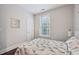 A bedroom with a patterned bedspread, large window, side table with lamp and a light color scheme at 3929 Glenlake Garden Dr, Raleigh, NC 27612