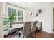 Inviting dining room with bench seating, modern light fixture, and large window views at 3929 Glenlake Garden Dr, Raleigh, NC 27612