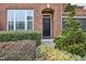 Inviting front entrance with a black door, brick archway, and lush, colorful landscaping at 3929 Glenlake Garden Dr, Raleigh, NC 27612