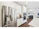 Modern kitchen featuring stainless steel appliances, white cabinets, and a view into the living room with a fireplace at 3929 Glenlake Garden Dr, Raleigh, NC 27612