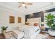 Inviting main bedroom with a tufted headboard, neutral colors, large windows, and a ceiling fan creating a serene atmosphere at 3929 Glenlake Garden Dr, Raleigh, NC 27612