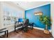 A comfortable home office with a blue accent wall, a large window, and ample workspace at 3929 Glenlake Garden Dr, Raleigh, NC 27612