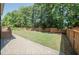 A view of a lush green backyard surrounded by a wooden fence and mature trees at 400 Leacroft Way, Morrisville, NC 27560