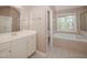 Bathroom with white cabinets, double sink, soaking tub, and shower at 400 Leacroft Way, Morrisville, NC 27560