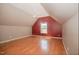 A bright, open bedroom features wood floors, a red accent wall, and a ceiling fan at 400 Leacroft Way, Morrisville, NC 27560