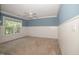 Blue bedroom with tan carpet, white wainscotting, and single window at 400 Leacroft Way, Morrisville, NC 27560