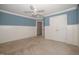 Blue bedroom with tan carpet, white wainscotting, window and closet at 400 Leacroft Way, Morrisville, NC 27560