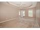 Neutral bedroom with tray ceiling, fan, carpet, and a view of the entry to the bathroom at 400 Leacroft Way, Morrisville, NC 27560
