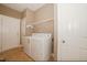 Functional laundry room with washer, dryer, wire shelving, and access door at 400 Leacroft Way, Morrisville, NC 27560