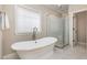 Bright bathroom showcasing a modern soaking tub with a glass shower enclosure and marble floors at 442 Hunters Pointe Rd, Nashville, NC 27856