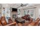 Cozy living room with stone fireplace, built-in shelving, and leather furniture at 442 Hunters Pointe Rd, Nashville, NC 27856