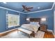 Blue bedroom features hardwood floors, bench seating, and a ceiling fan at 442 Hunters Pointe Rd, Nashville, NC 27856