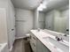 Modern bathroom featuring double sinks, gray tile flooring, and white cabinets at 5014 Kota St, Raleigh, NC 27610
