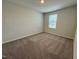 Cozy bedroom features plush carpet, neutral paint, and a window with a view of the outdoors at 5014 Kota St, Raleigh, NC 27610