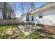 Backyard features a cozy patio set, a partial brick foundation, a wooden fence, and a manicured lawn at 513 Jaffiley Ct, Wake Forest, NC 27587