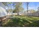 Backyard boasts a patio set, a well-maintained lawn, a wooden fence, mature trees, and a storage shed at 513 Jaffiley Ct, Wake Forest, NC 27587