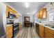 Open kitchen boasts stainless steel appliances, wood cabinets, and wood floors, perfect for cooking and entertaining at 513 Jaffiley Ct, Wake Forest, NC 27587