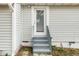 A back entrance featuring steps leading to the door with glass pane and mini blinds on a light gray home at 513 Kenway St, Garner, NC 27529