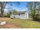 Exterior view of the home from the backyard, showing the home's light gray siding and a large yard with mature trees at 513 Kenway St, Garner, NC 27529