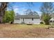 Exterior view of the home from the backyard showing a large yard and a light gray home at 513 Kenway St, Garner, NC 27529