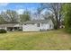 Quaint home with light gray siding, surrounded by lush trees and a spacious lawn, offering a serene residential setting at 513 Kenway St, Garner, NC 27529