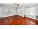 Inviting living room with hardwood floors, large windows, and a classic ceiling fan for comfortable and stylish living at 513 Kenway St, Garner, NC 27529
