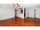 Open-concept living room with hardwood floors, a ceiling fan, and a partial view of the kitchen for easy entertaining at 513 Kenway St, Garner, NC 27529